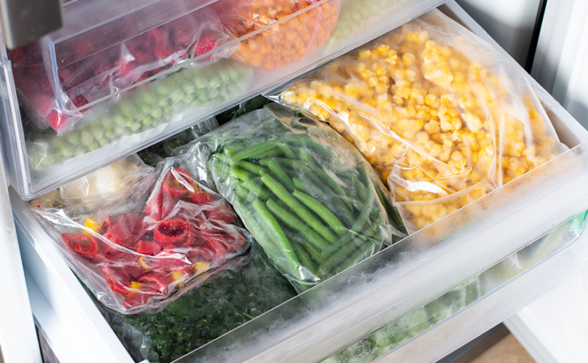 Frozen produce including green beans and corn in plastic bags