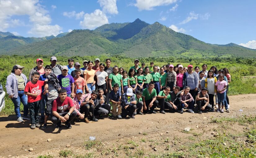 employees and community members gather with mountains in the background