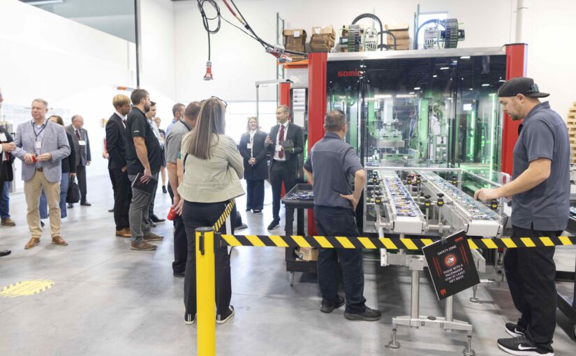 Visitors tour a bright manufacturing facility