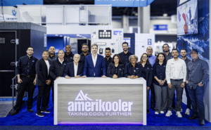 A group of employees pose in front of a counter with the Amerikooler logo
