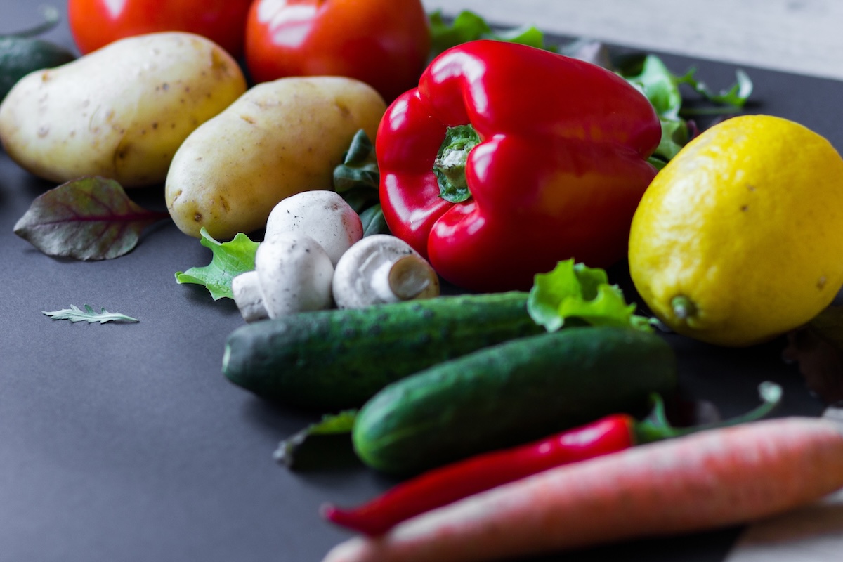 An array of brightly colored produce including red peppers and cucumbers
