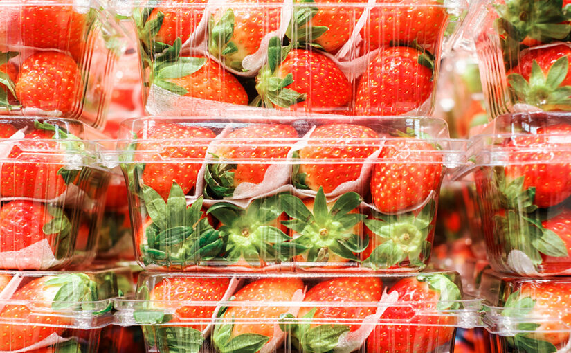 A closeup of fresh strawberries sealed in plastic packaging
